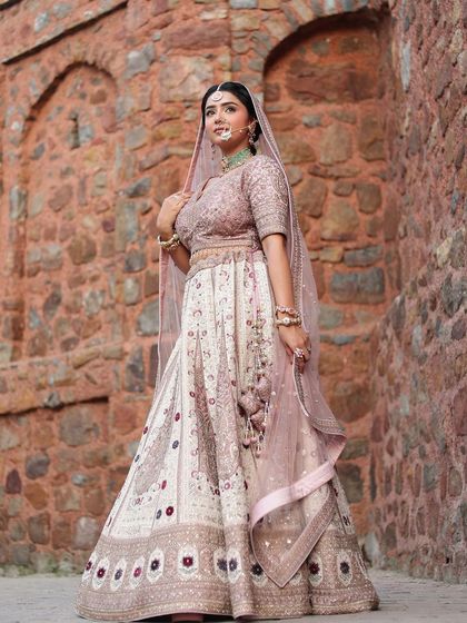 A full-length shot of the royal pastel bridal lehenga. The detailed work and the soft color palette make it a truly unique piece.