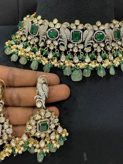 A stunning Victorian choker with parrot motifs and green beadwork. The matching earrings are designed to make a statement. This is a very popular rental for sangeets.