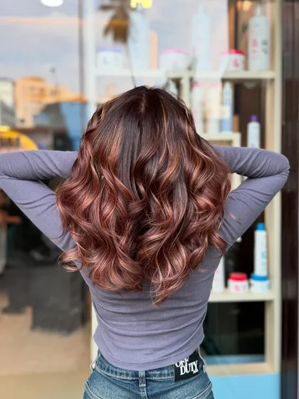 Another 2024 favorite. A beautiful balayage with warm, coppery-red tones that look like they're on fire.