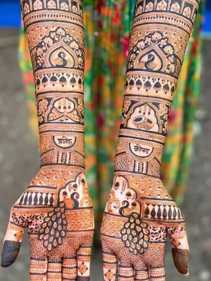 This design features graceful peacocks on the palms and arms, with the couple's names, Pratik and Komal, written in Hindi. It's a beautiful blend of artistry and personalization.