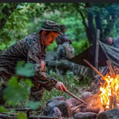 A participant in our jungle survival course learns how to build and manage a fire using natural materials. This is a fundamental skill taught by our expert instructors in a real wilderness setting.
