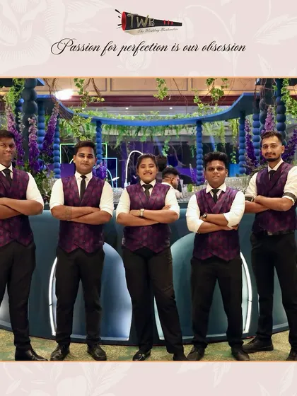 Our team of bartenders in stylish purple vests, posing in front of the magnificent bar they managed for a Sangeet at Taj Lands End.