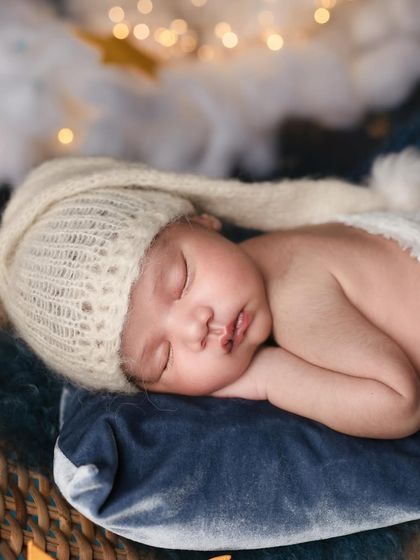 Gently swaying into dreams. This close up shot focuses on the baby's serene expression and the cozy texture of their knitted hat.
