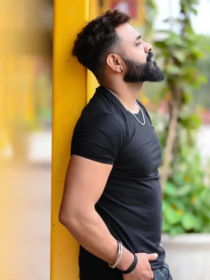 An outdoor portrait of a male model against a vibrant yellow wall. The contrast and composition create a strong, eye-catching image for a fitness or street style portfolio.