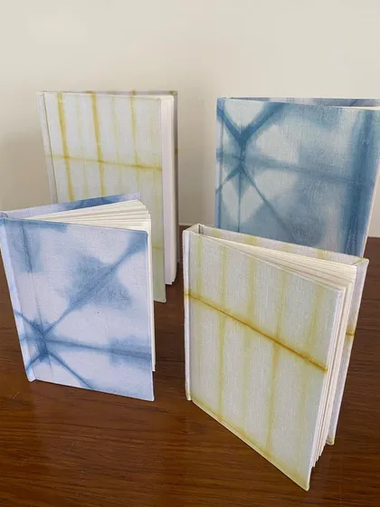 A set of four tie-dyed notebooks, two in indigo blue and two in marigold yellow. They make a beautiful set for gifting or for your own personal use.