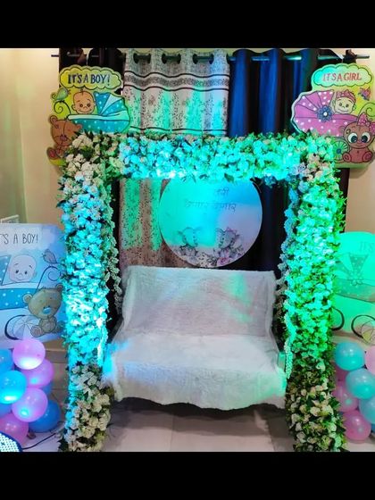 A view of the home baby shower decoration with cool blue lighting, giving the floral arch a unique and modern appearance.