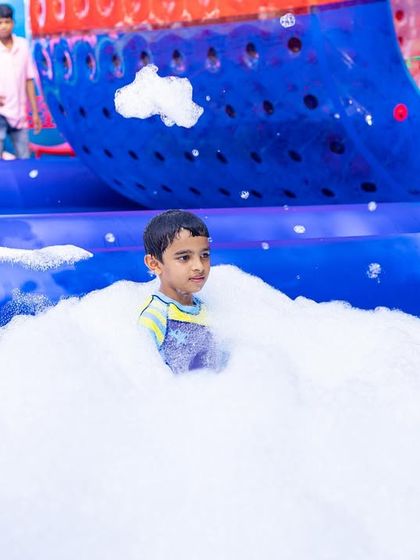 A young boy having a blast in the foam pit. The foam is hypoallergenic and safe for children, making it a worry-free activity for parents.