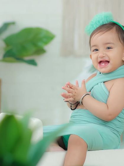A bright, happy smile from this little girl in a mint green dress. The simple, natural-light setting creates a fresh and airy portrait.