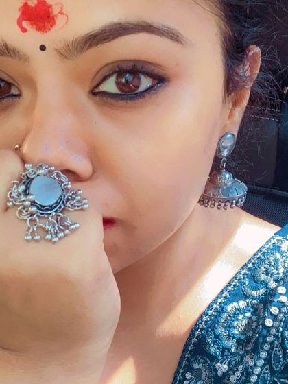 A close-up showing the details of the look: a red bindi, silver jhumkas, and a statement ring, all coming together to create a powerful traditional aesthetic.