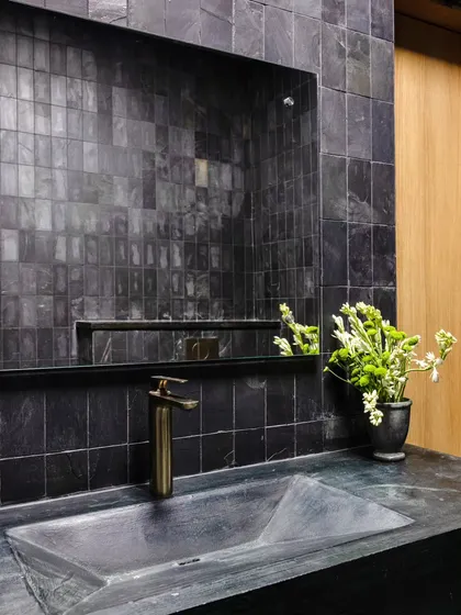A detail of the washroom at Anthea Pharma, showcasing my focus on material craftsmanship. The walls and floor are clad in rugged Kadappa stone, paired with a bespoke concrete basin and matte French gold fittings for a raw yet luxurious feel.