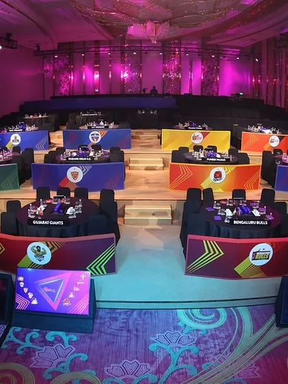 An overview of the auction hall for the PKL Player Auction. We designed the layout with color-coded tables for each of the 12 franchises, creating a visually organized and professional environment.