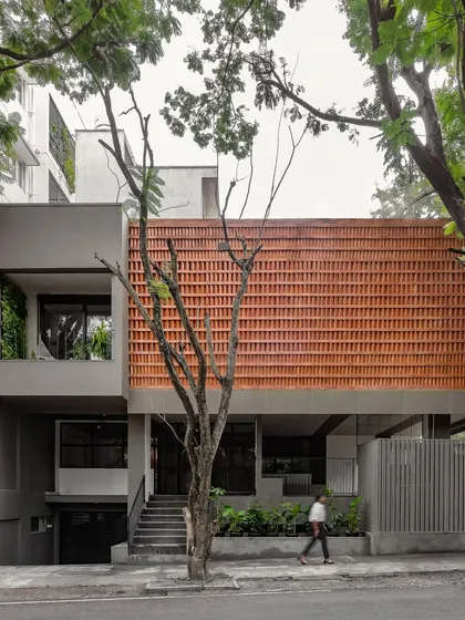 This is our own studio, Akshara Vinyasaa, where our design philosophy comes to life. The facade features a screen of locally sourced terracotta bricks, a climate-responsive element that provides natural cooling while creating a visual connection to the earth.