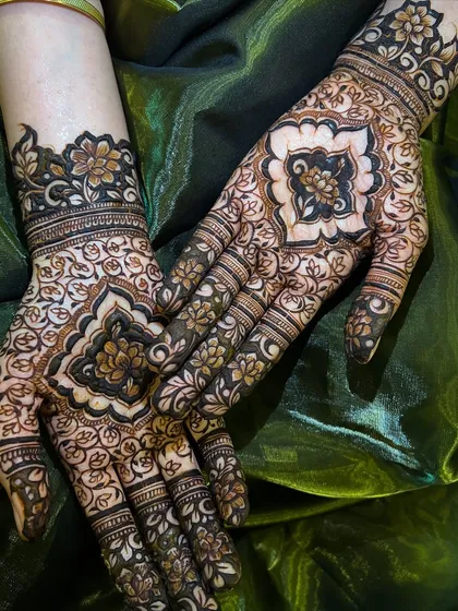 This design features a central mandala like pattern on the back of the hands, surrounded by delicate floral vines. It's a classic and elegant choice for any festive event.
