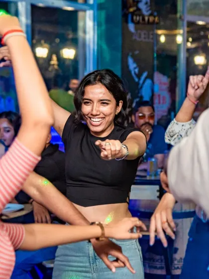 A guest pointing at the camera while dancing with friends. It's an interactive, fun-filled night.