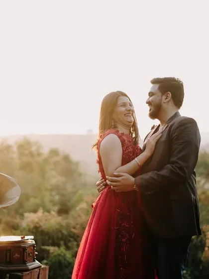 A joyful, candid moment of laughter and embrace, with the soft golden light of sunset creating a magical atmosphere in the hills.