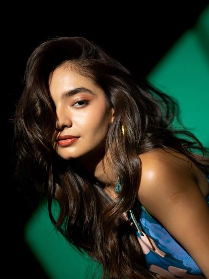 A classic beauty shot where part of the face is in shadow, creating a sense of mystery and focusing the viewer's attention on her eyes.