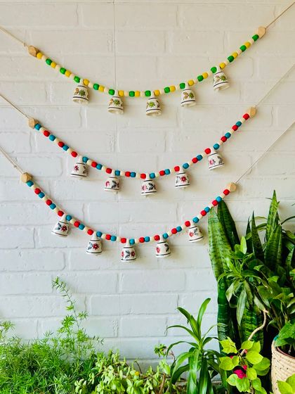 Another look at our 'Khanak' beaded bell buntings, perfect for adding a touch of elegance and charm to your home. The combination of vivid wooden beads and mini ceramic bells creates a harmonious blend of color and sound.