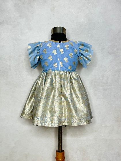 The back view of the Mogra blue dress, showing the simple zip and flutter sleeves.