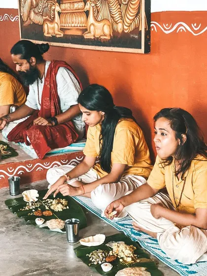 Students and teachers share a traditional meal served on banana leaves. This communal way of eating is a beautiful and grounding part of the ashram experience.