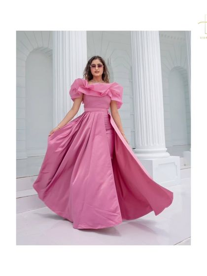 A full-length shot of the high-fashion pink gown with dramatic ruffled shoulders.