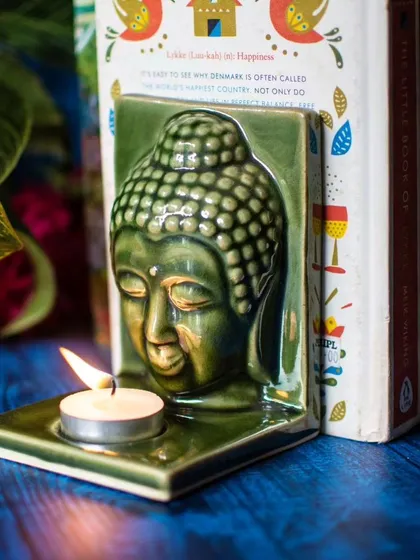 We love creating pieces that are both beautiful and versatile. This serene, green ceramic Buddha head is designed not just as a tealight holder, but also as a unique bookend to bring a sense of peace to your bookshelf.