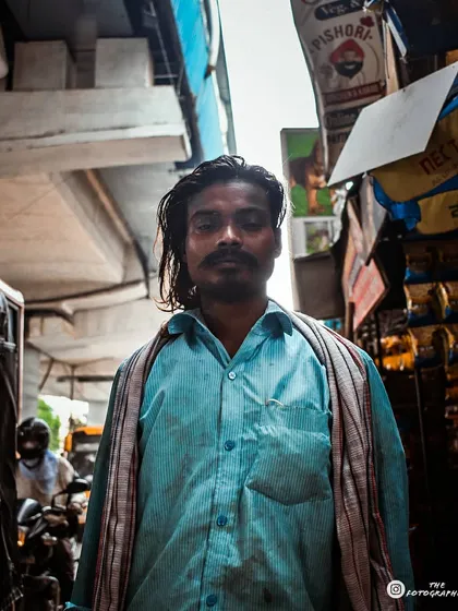 This portrait was taken under a flyover, using the urban environment as a backdrop. The soft light and the subject's direct gaze create a powerful image that feels very grounded in its setting.