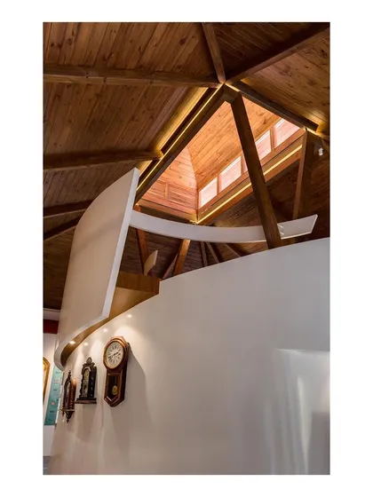 Looking up at the timber roof structure and the new mezzanine level. This view highlights the vertical volume of the original building and how our intervention works within it.