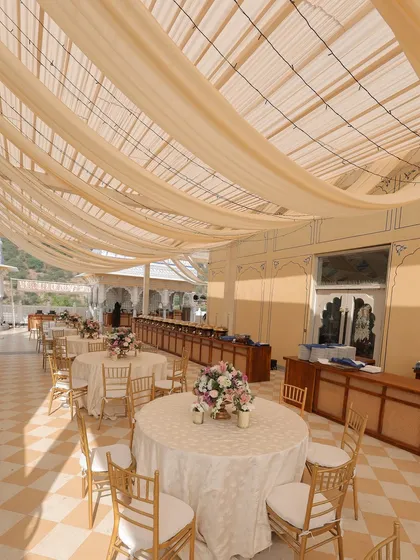 The dining area for the pheras, with tables covered in elegant patterned linens and draped ceilings creating a soft, tent-like effect.