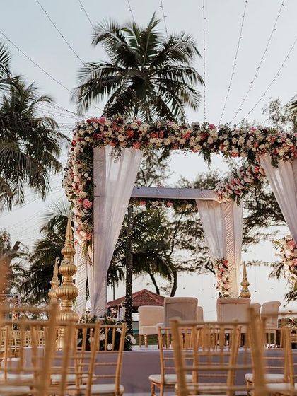 A stunning floral mandap set against the backdrop of a Goa sunset. Planning a destination wedding means using the location to its fullest potential for breathtaking results.