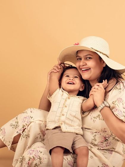 A playful moment between mother and child. The hat adds a touch of whimsy to this sweet and candid studio portrait.