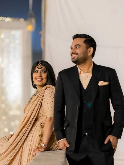 A candid moment from an evening function, with the groom looking on as his bride smiles.