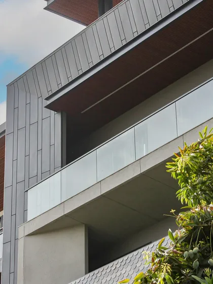 A detail shot of the Akashneem Marg facade, focusing on the clean lines and the interplay of different grey and brown tones. The design is a study in modern, minimal aesthetics.