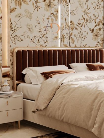 A luxurious bedroom featuring a channel-tufted velvet headboard, floral wallpaper, and mirrored panels with integrated wall sconces.
