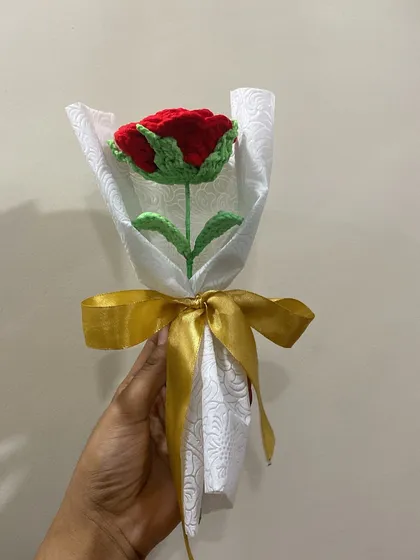A single red rose wrapped in elegant white paper with a gold ribbon. It's a classic for a reason.