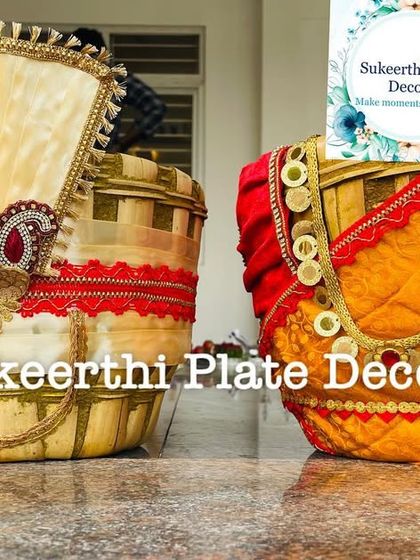 A close-up of a decorated Uppukudai pair, showing the detailed fabric work and the 'kasu malai' style necklace on the bride basket.