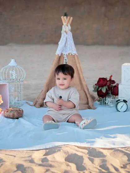 A full view of our boho-chic beach picnic setup, complete with a teepee, lanterns, and flowers, creating a beautiful scene on the sand.