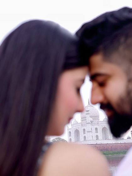 An intimate close-up where the focus is on the couple, with the Taj Mahal softly blurred in the background, symbolizing that your world is each other.