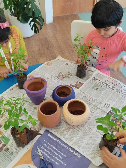 Another view of our little gardeners at work, learning how to handle soil and plants with care.