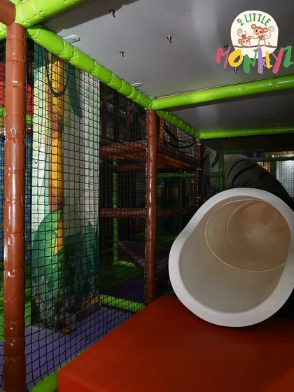 Get ready to crawl, climb, and explore! This shot shows one of our exciting tube slides and the intricate, safely-netted structure of our multi-level jungle gym. It's a maze of fun waiting to be discovered.