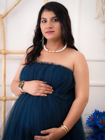 A lovely close-up portrait of an expecting mother. Her serene expression and the soft details of her pearl necklace create a classic and timeless maternity photo.