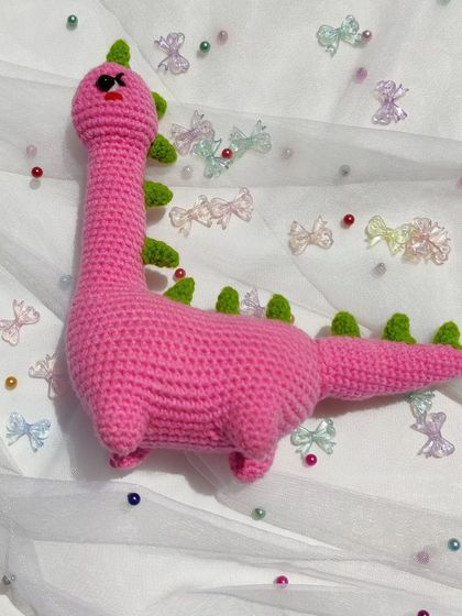 A top-down view of the pink dinosaur plushie.