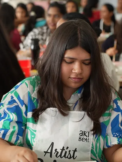 A participant wearing our "Artist Painter" apron at the Meesho event. We provide all the necessary materials, including aprons to keep things tidy.