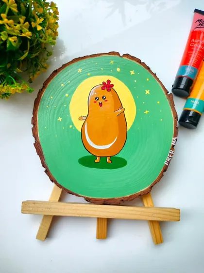 The front view of the "cute potato" wooden log painting. This quirky and adorable character is painted with acrylics and is meant to bring a smile to your face.