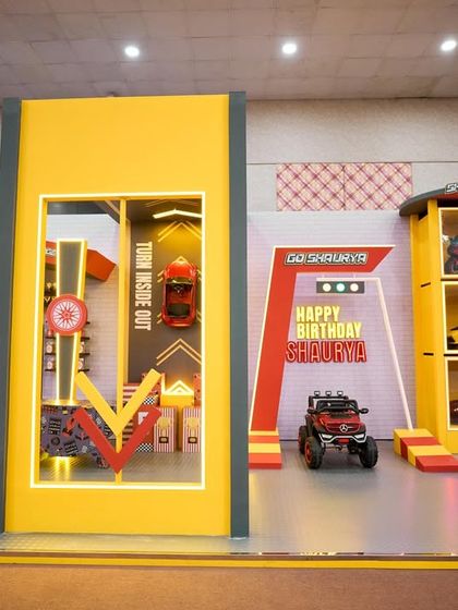 A wide shot of the entire race car themed setup, showing the different zones for photos, games, and activities, all unified by a bold, graphic design.