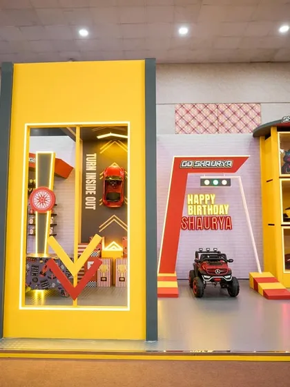 A wide shot of the entire race car themed setup, showing the different zones for photos, games, and activities, all unified by a bold, graphic design.