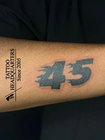 The number "45" tattooed in a bold, stylized font with a motion blur effect, often representing a favorite player or a significant number.