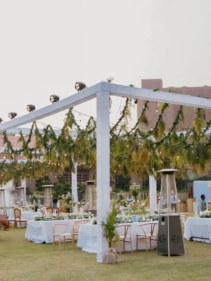 The elegant outdoor seating for our 'Luxe Garden' wedding. We used clean white pergolas draped with fresh greenery and Edison bulbs to create a sophisticated and intimate dining space for the evening.
