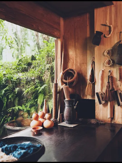 A still-life detail from the 'Pause' campaign set. The curated props, including pottery and natural brushes, help build the world of a creative, mindful retreat.