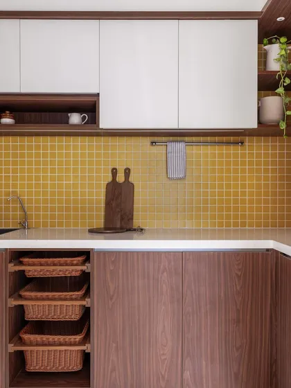 This kitchen from our 'Living Life in Colour' project features a warm combination of walnut-finish cabinets and a mustard yellow tile backsplash, creating a cozy and inviting atmosphere.