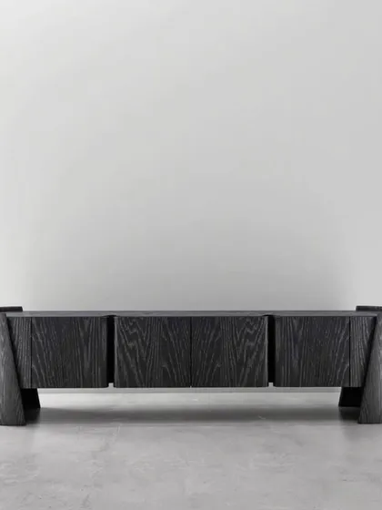 Details that define distinction. This sideboard in a dark, open-grain wood finish features a powerful, sculptural form with curved end supports.